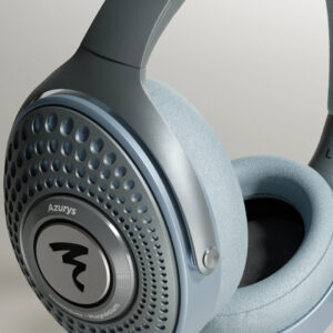 Over-ear light blue headphones close-up showing perforated ear cup and brand logo on the metallic plate.